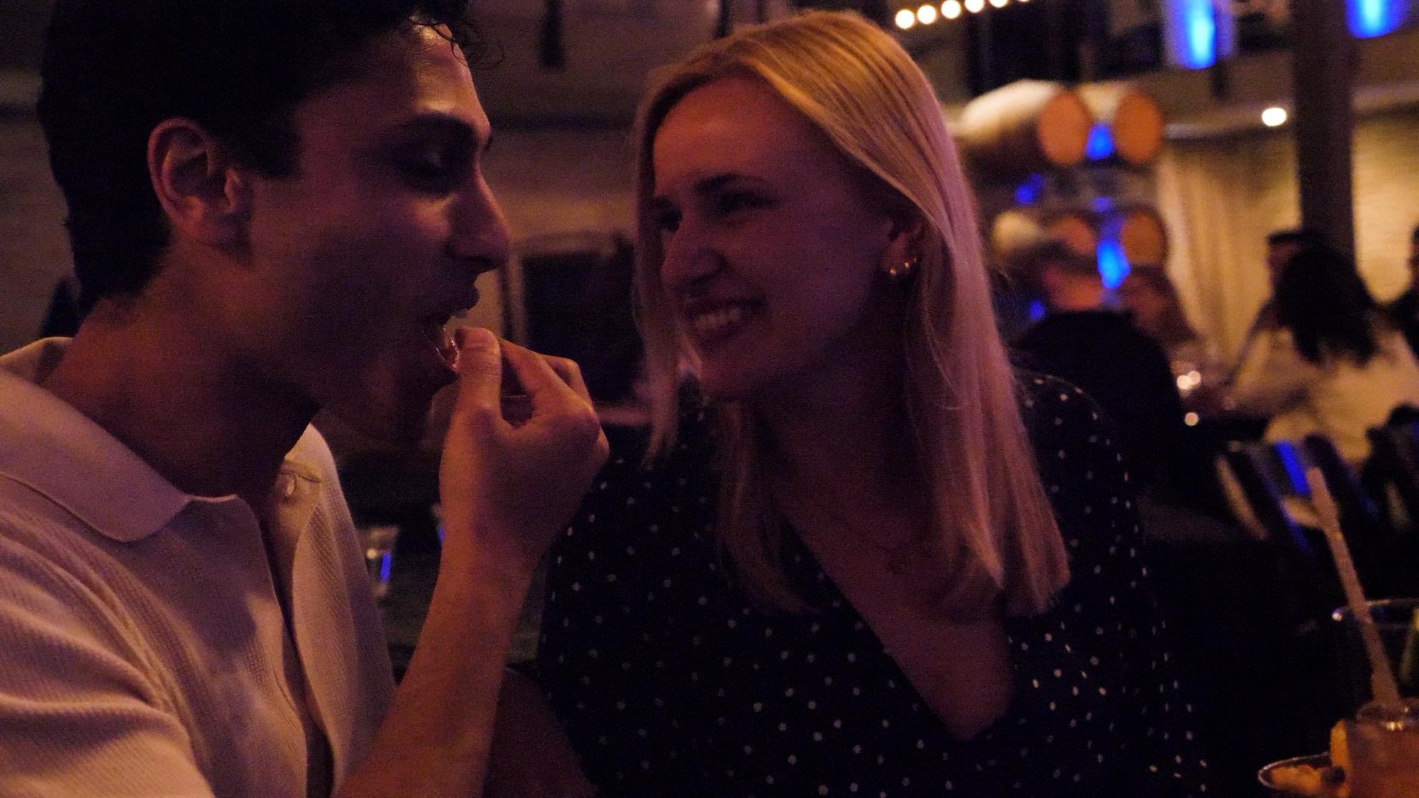 A couple laughing together at a comedy show in Domenico Winery's barrel room